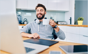 Image of a man on the computer and  with a cup of coffee