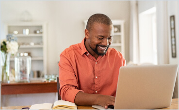 Image of a man on the computer smiling